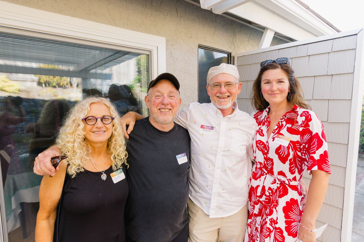 Guests smiling and posing together at a sunny outdoor social event.