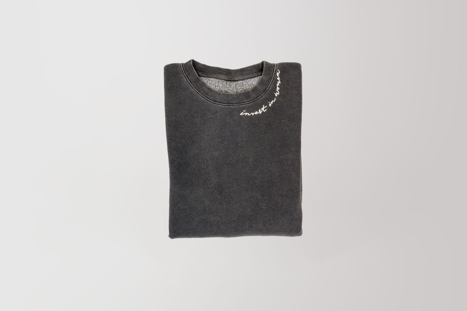 Dark grey sweatshirt folded and photographed from above on white background.