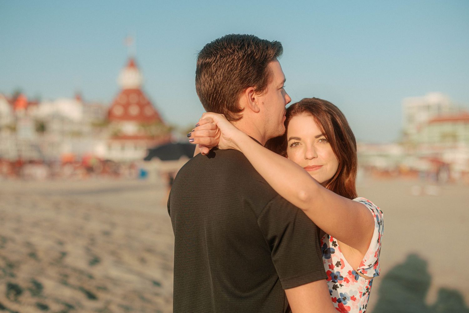 A romantic beach photoshoot with the Hotel del Coronado visible in the background.