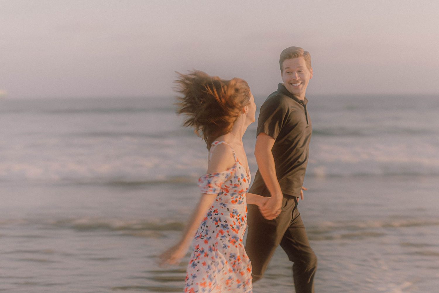 Dancing together on the beach during a romantic sunset photoshoot.