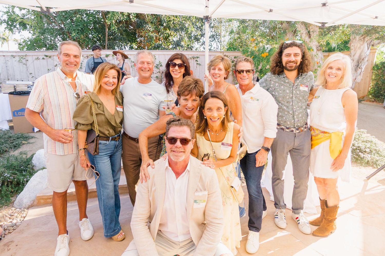 Party guests mingling and chatting at a casual outdoor summer event.