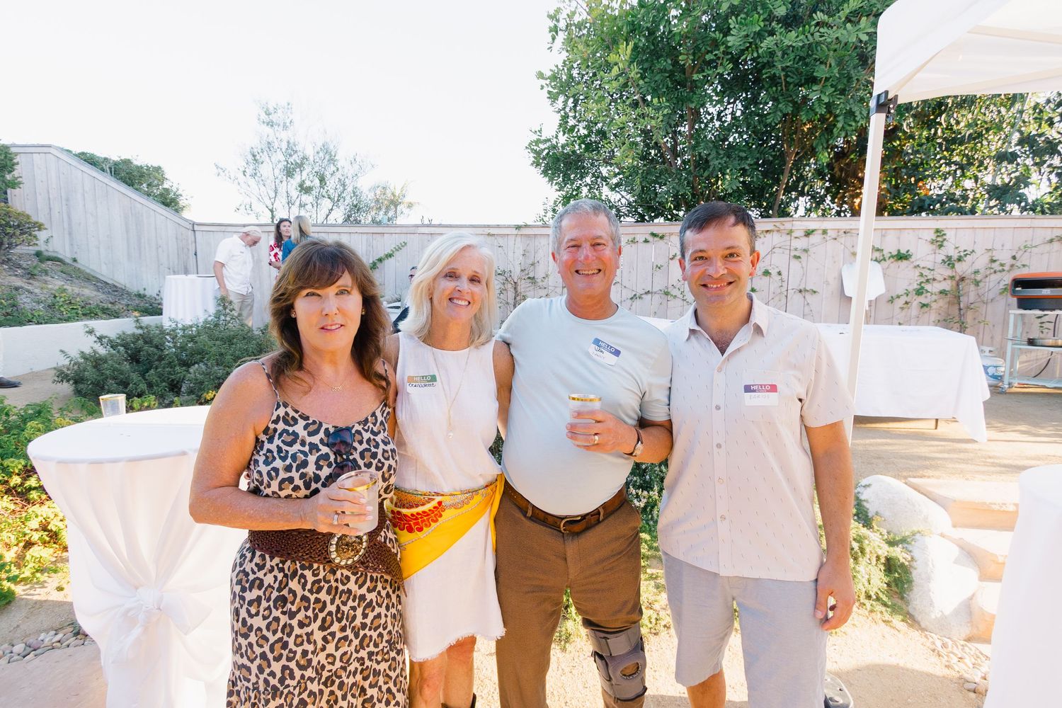 Friends gathering and holding drinks at a summer outdoor party.
