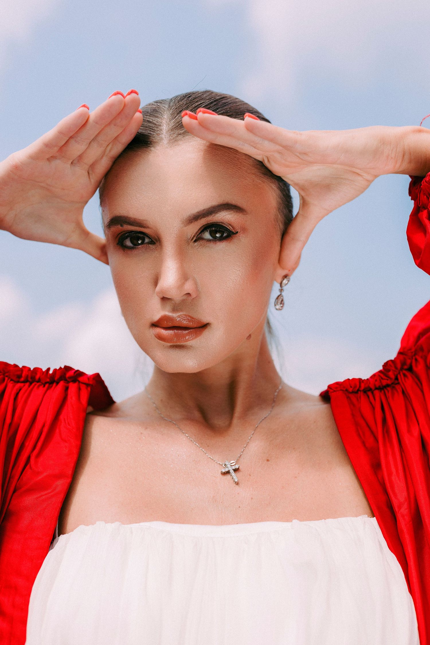 Portrait in red and white clothing against a blue sky background.