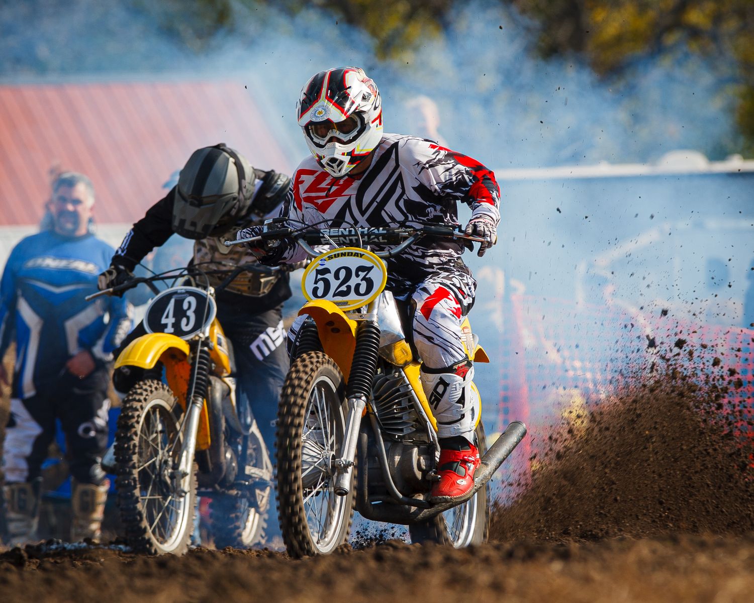 Dirt bikes kick up mud and dust during intense motocross racing action.