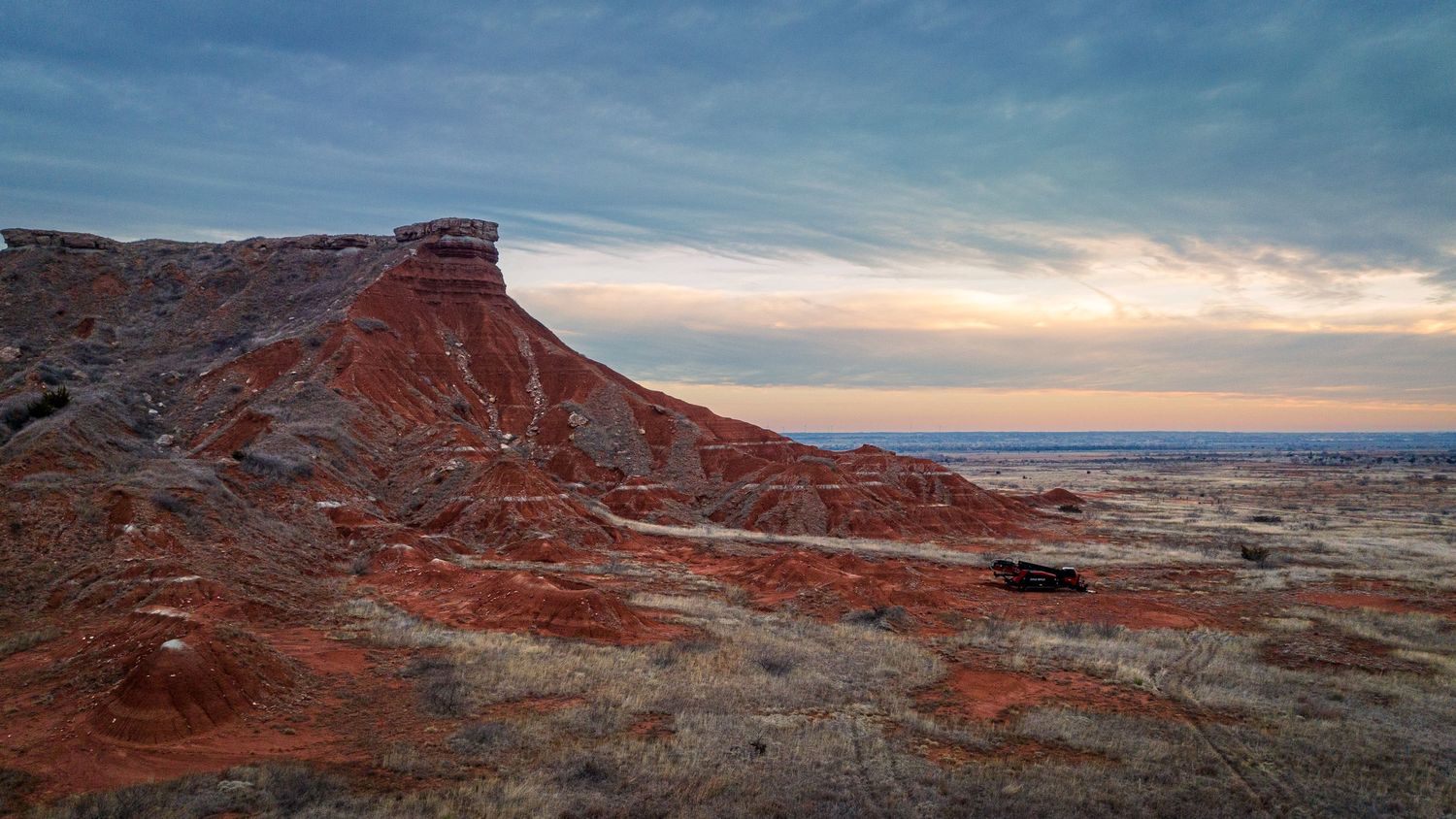 Stunning red rock mesa formations against a cloudy sunset sky.