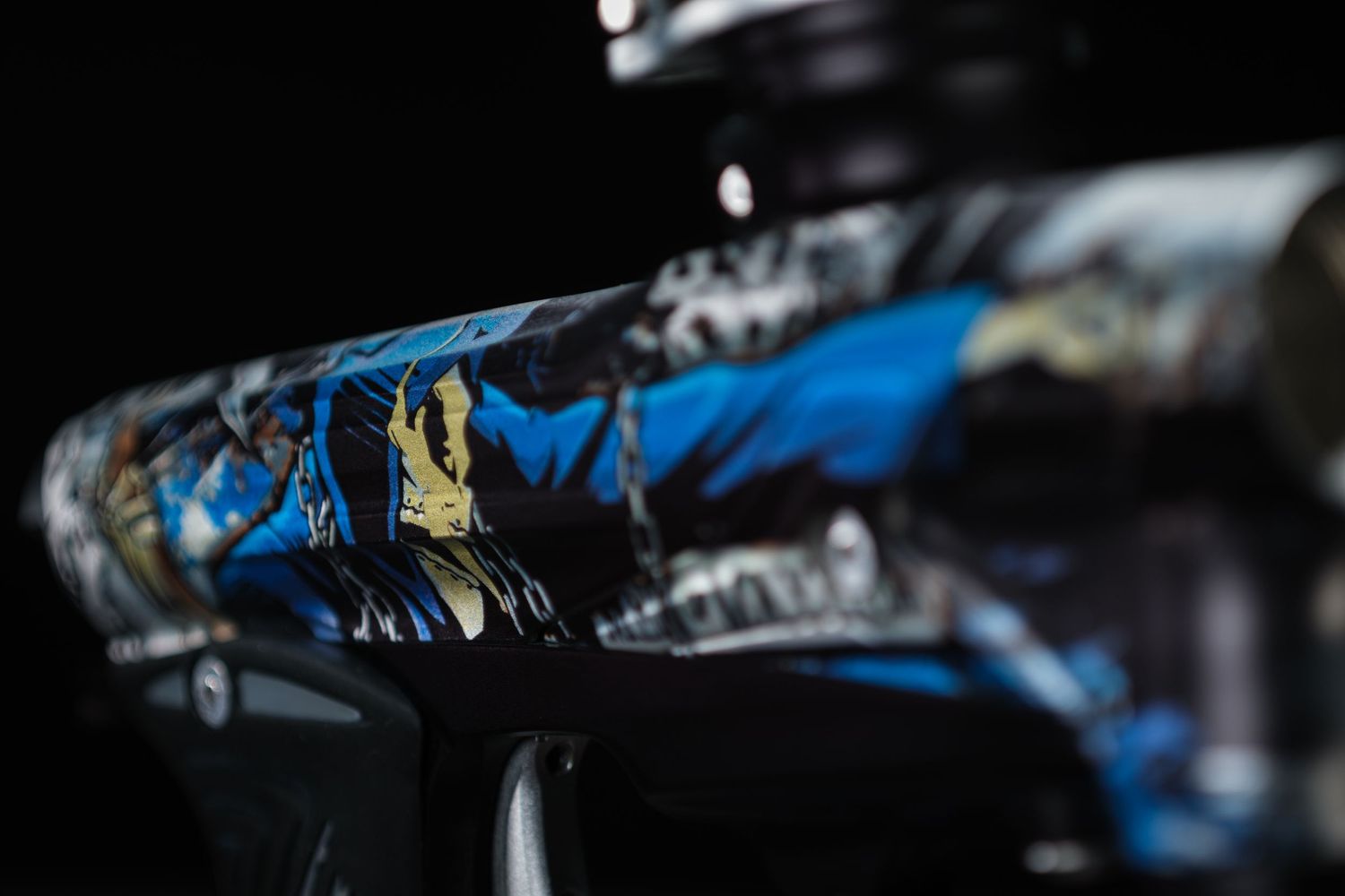 Close-up detail shot of a metallic frame with blue and black textured surface in low light.