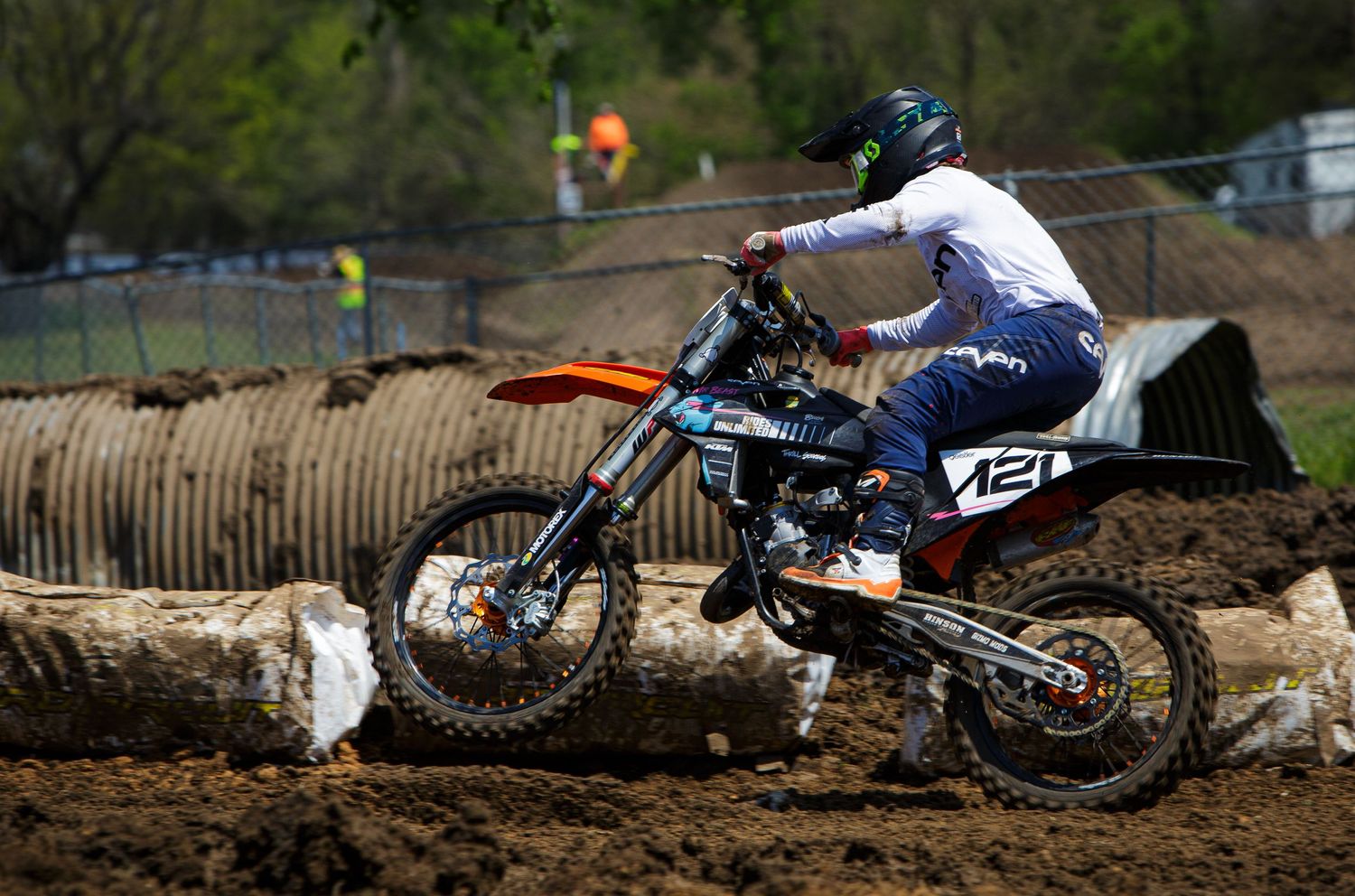 Motocross rider navigating a dirt track on their racing bike during competition.