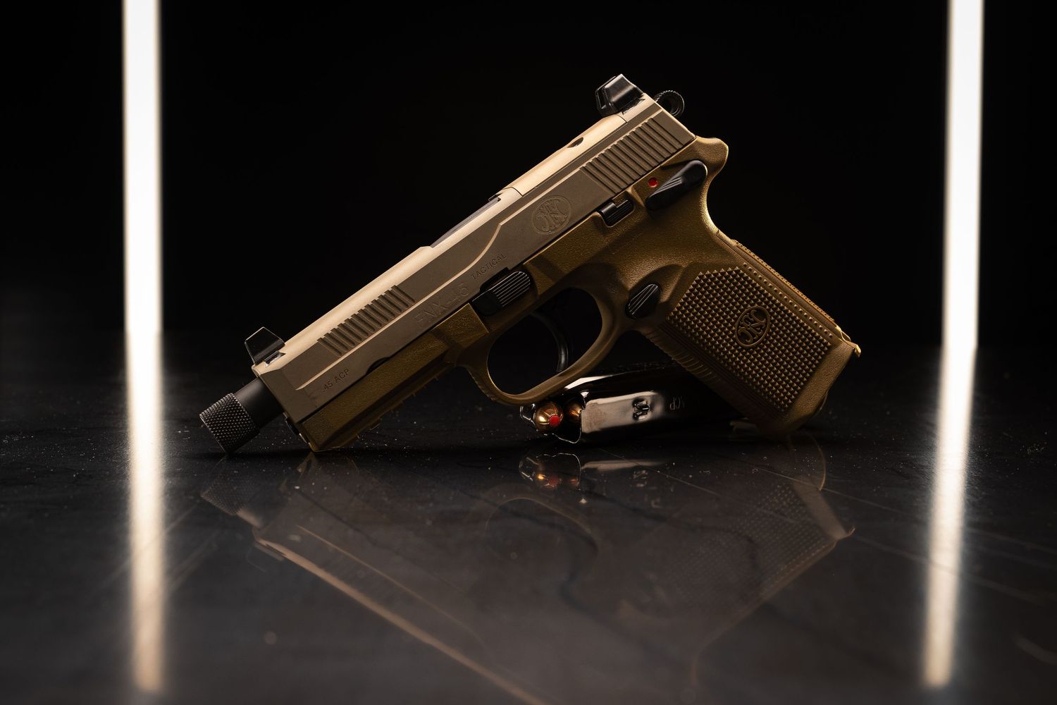 Bronze colored pistol on reflective black surface with dramatic studio lighting.