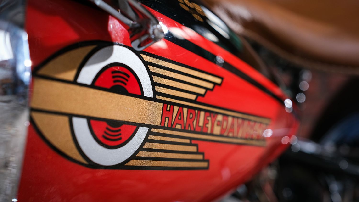Close-up of red Harley-Davidson motorcycle parts showing chrome and paint details.