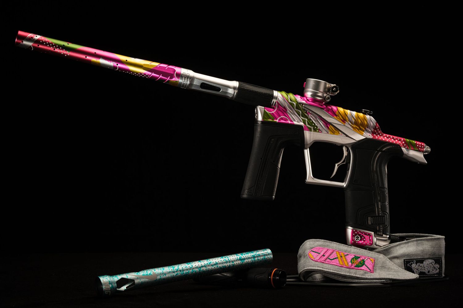 Colorful paintball gun with custom design displayed against black background.