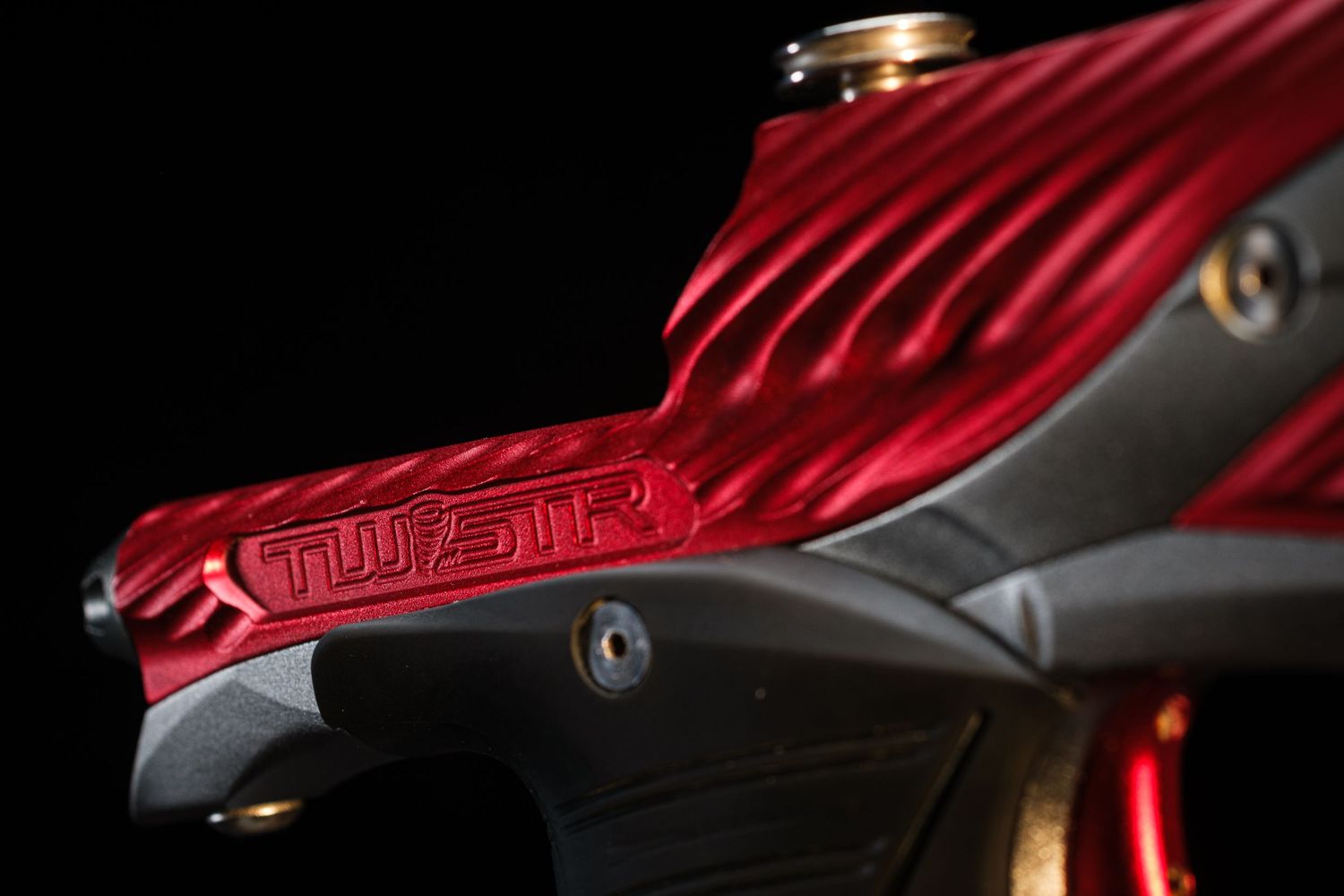 Red textured surface with curved ridges shown in dramatic lighting against dark background.