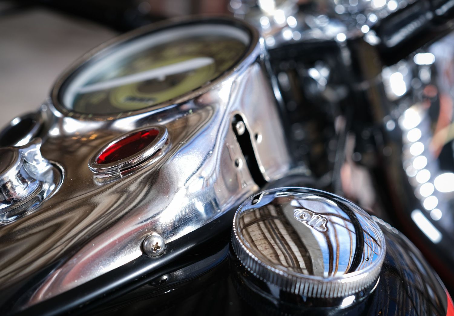 Chrome motorcycle parts and gauges reflecting light in dramatic detail shot.