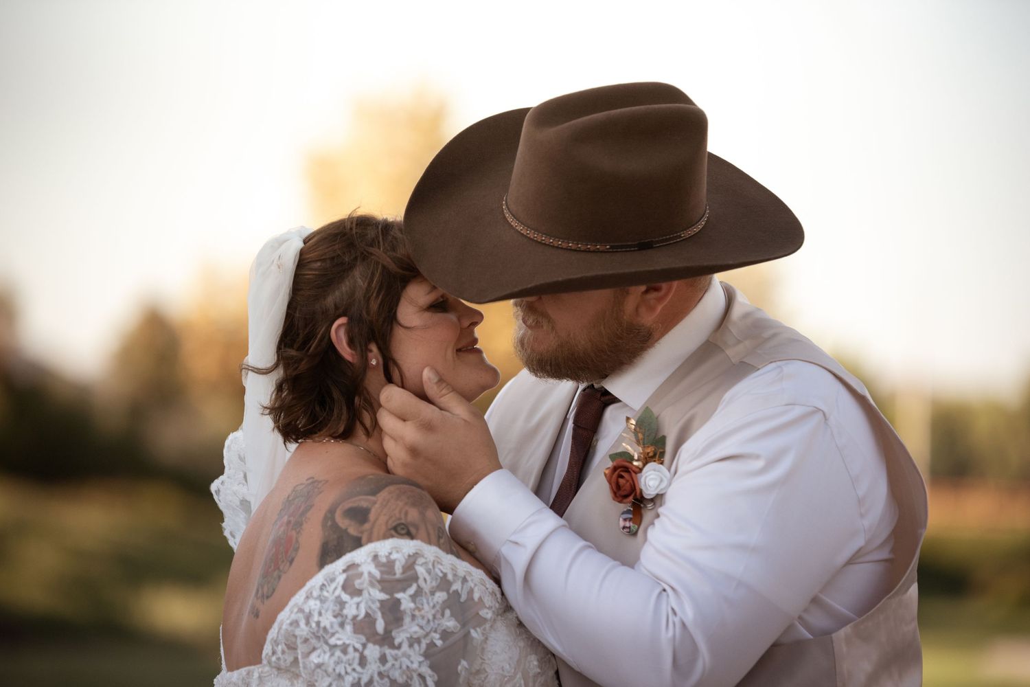 Romantic photo series of newlyweds sharing intimate moments at sunset in rustic western attire.