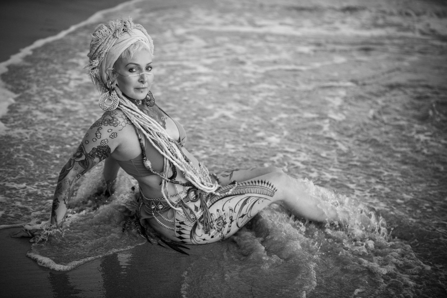 Black and white photo of person posing in shallow ocean water.