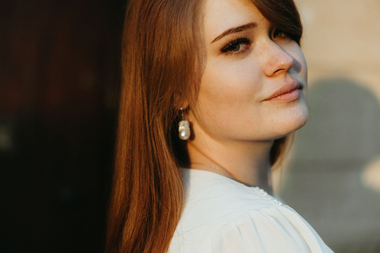 Red Head girl looking straight at the camera with a large organic pearl earring