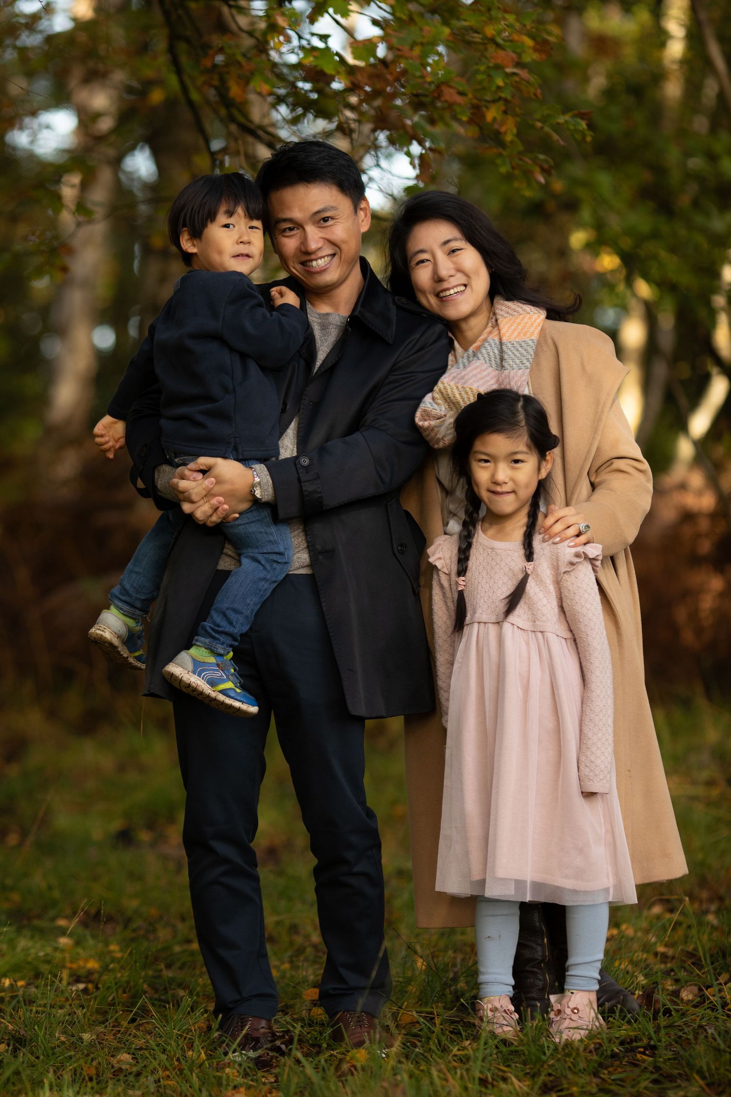 Family group photo session in autumn park with coordinated outfits.