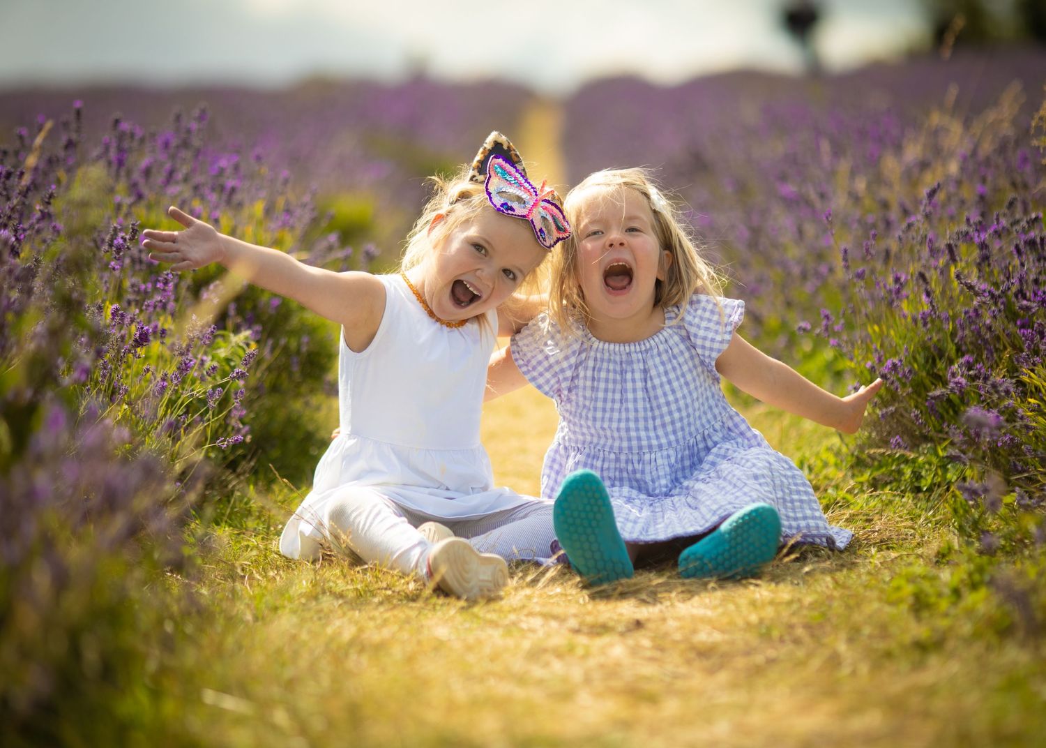 Children playing in blooming lavender field at sunset.