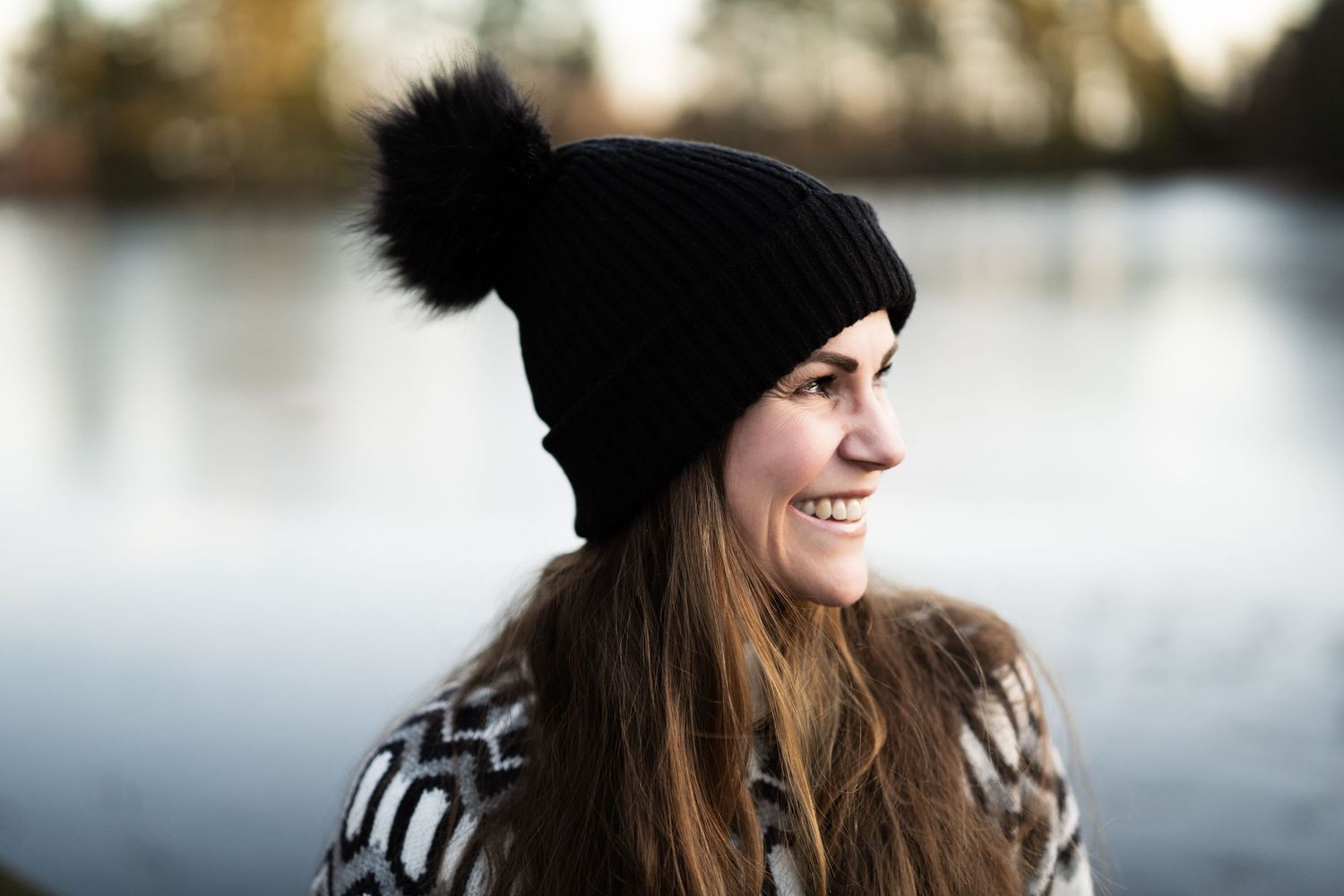 Naturlig portrett av kvinne i ullgenser og lue ved vann – utendørs fotografering i Sandefjord
