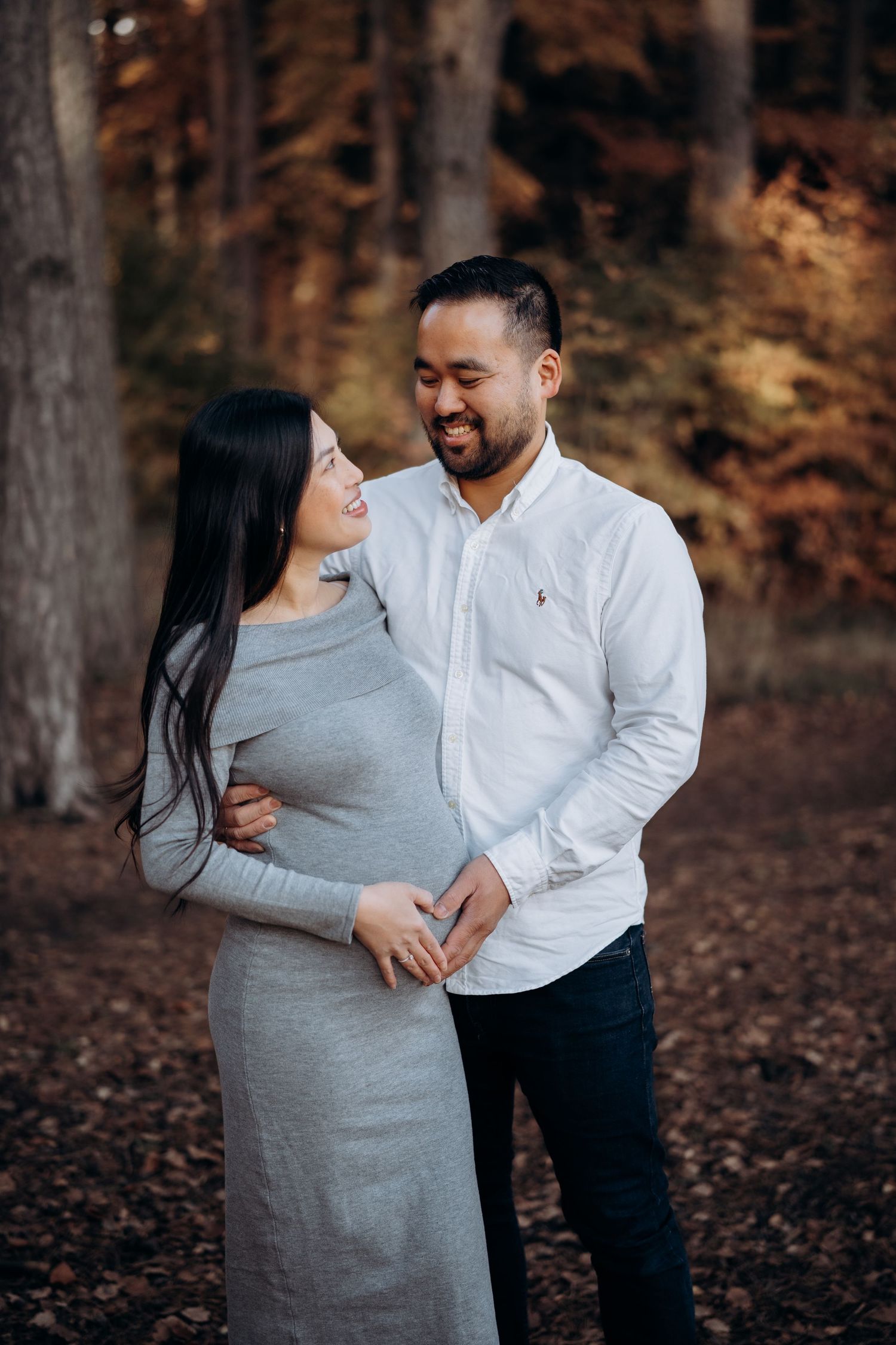 Portrett fotografering av gravid dame sammen med mannen sin. De står ute omringet av høstfarger.