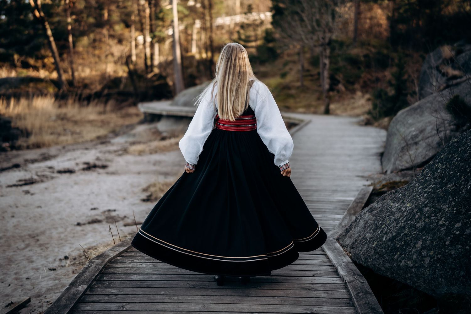 Konfirmasjonsfotogarfering - Konfirmant som svinger kjolen sin rundt i ring - har på seg en beltestakkbunad.