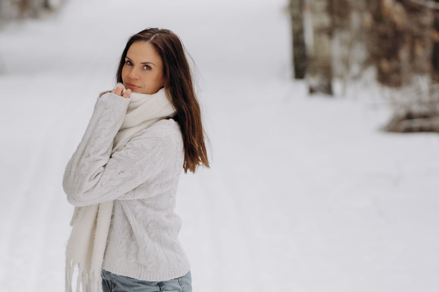 Portrettbilde av Natasha Skoli, fotografen som står ute i lyse klær i skogen i Sandefjord