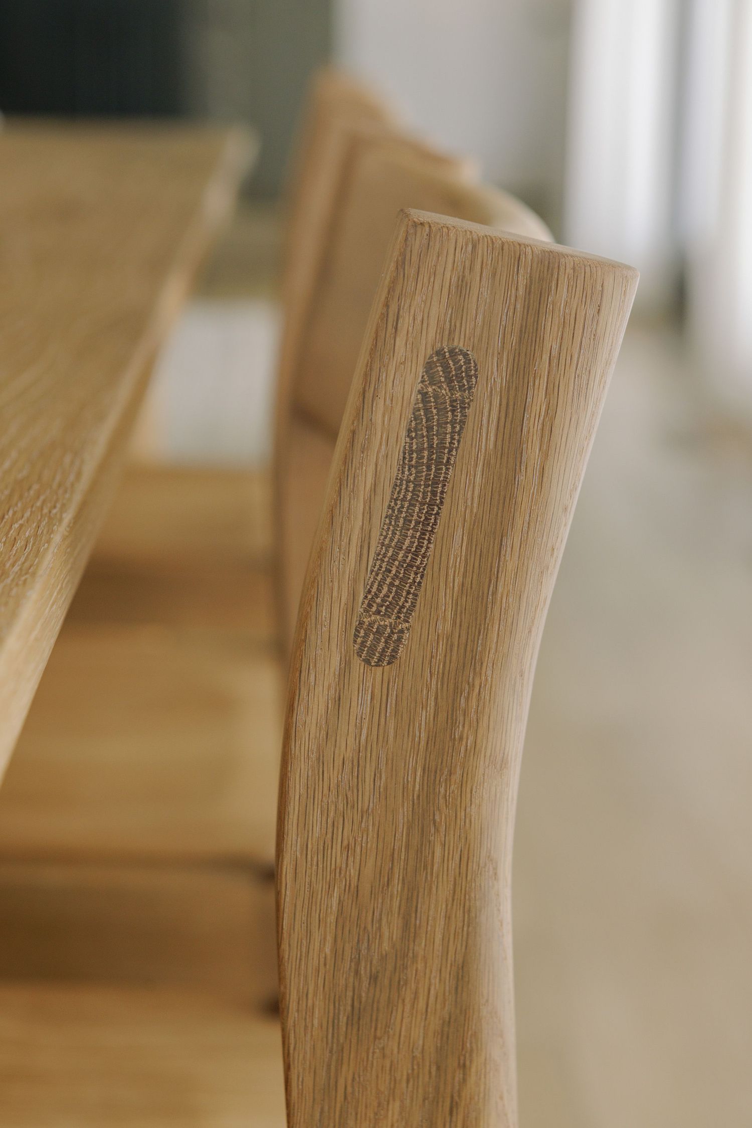 Detailed view of wood grain patterns and stamped text on light-colored wooden furniture surface.