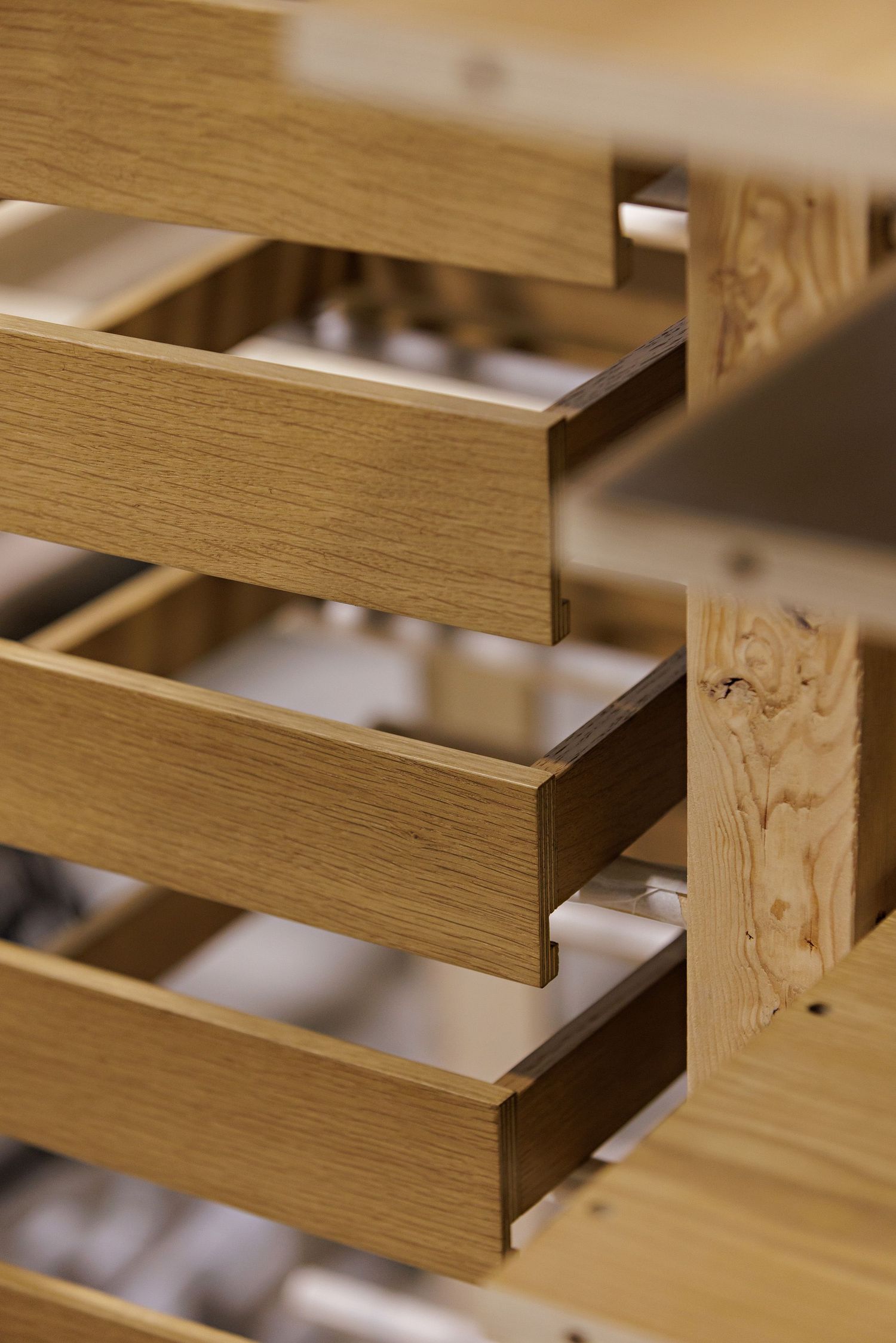 Close-up view of wooden drawers showing parallel lines of light oak construction details and craftsmanship.