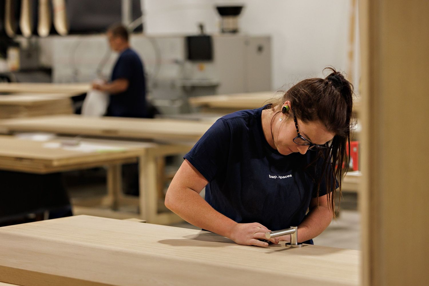 Student in navy blue shirt works diligently at desk in classroom laboratory setting.