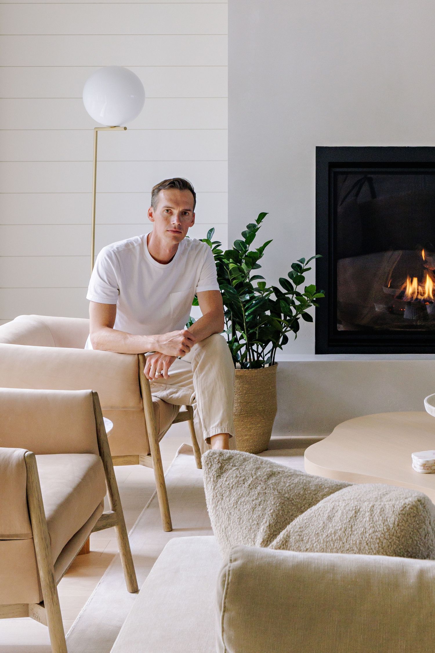 Cozy modern living room with fireplace, round floor lamp, and neutral furnishings.