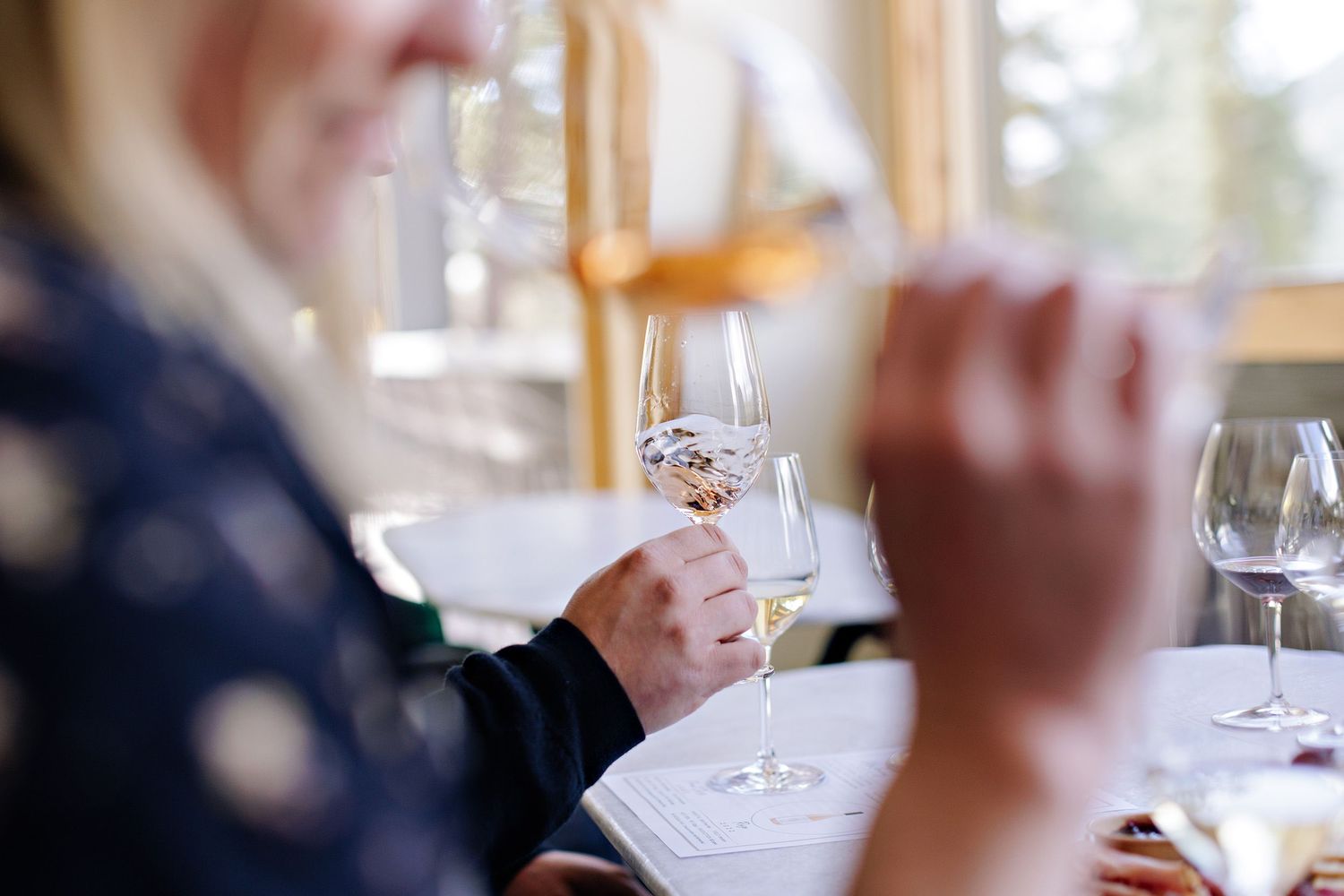Wine glasses on a table during a wine tasting event with soft focus background.