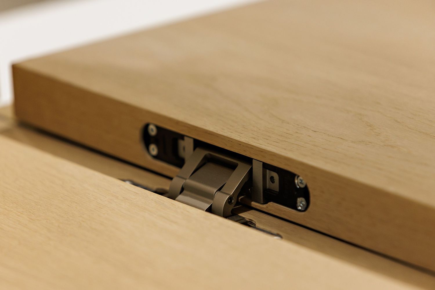 Close-up detail of a wooden box hinge mechanism showing craftsmanship and construction.
