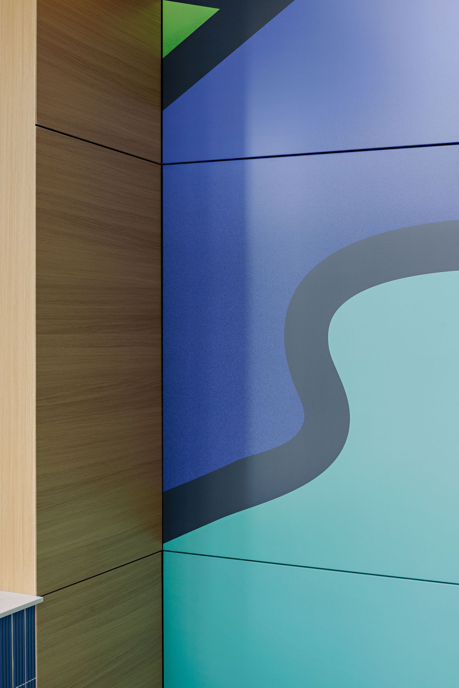 Modern architectural detail showing wood paneling against a curved blue and turquoise wall design.