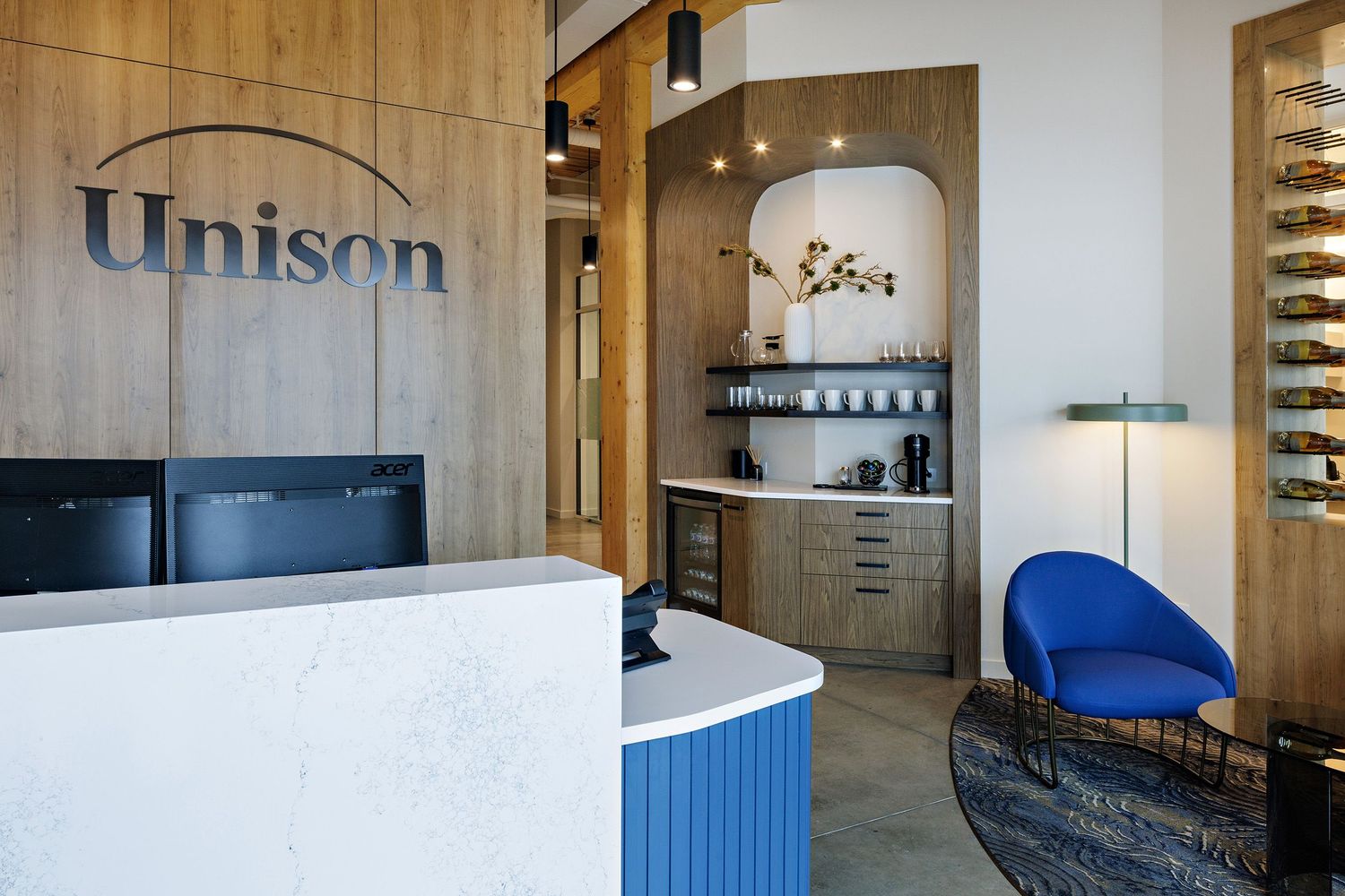 Modern dental office reception area with blue and white curved desk, wooden accents, and built-in cabinet storage.