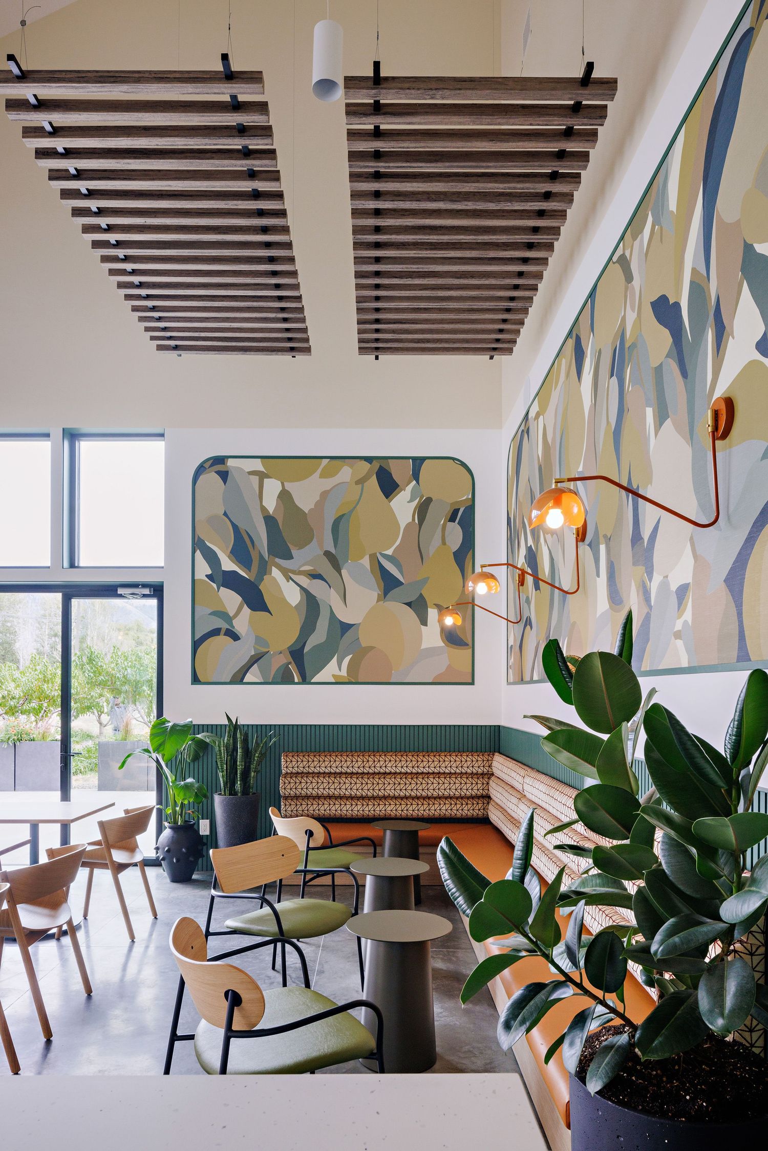 Modern restaurant interior with wooden ceiling beams, abstract wall art, and mid-century furniture creates a stylish dining atmosphere.