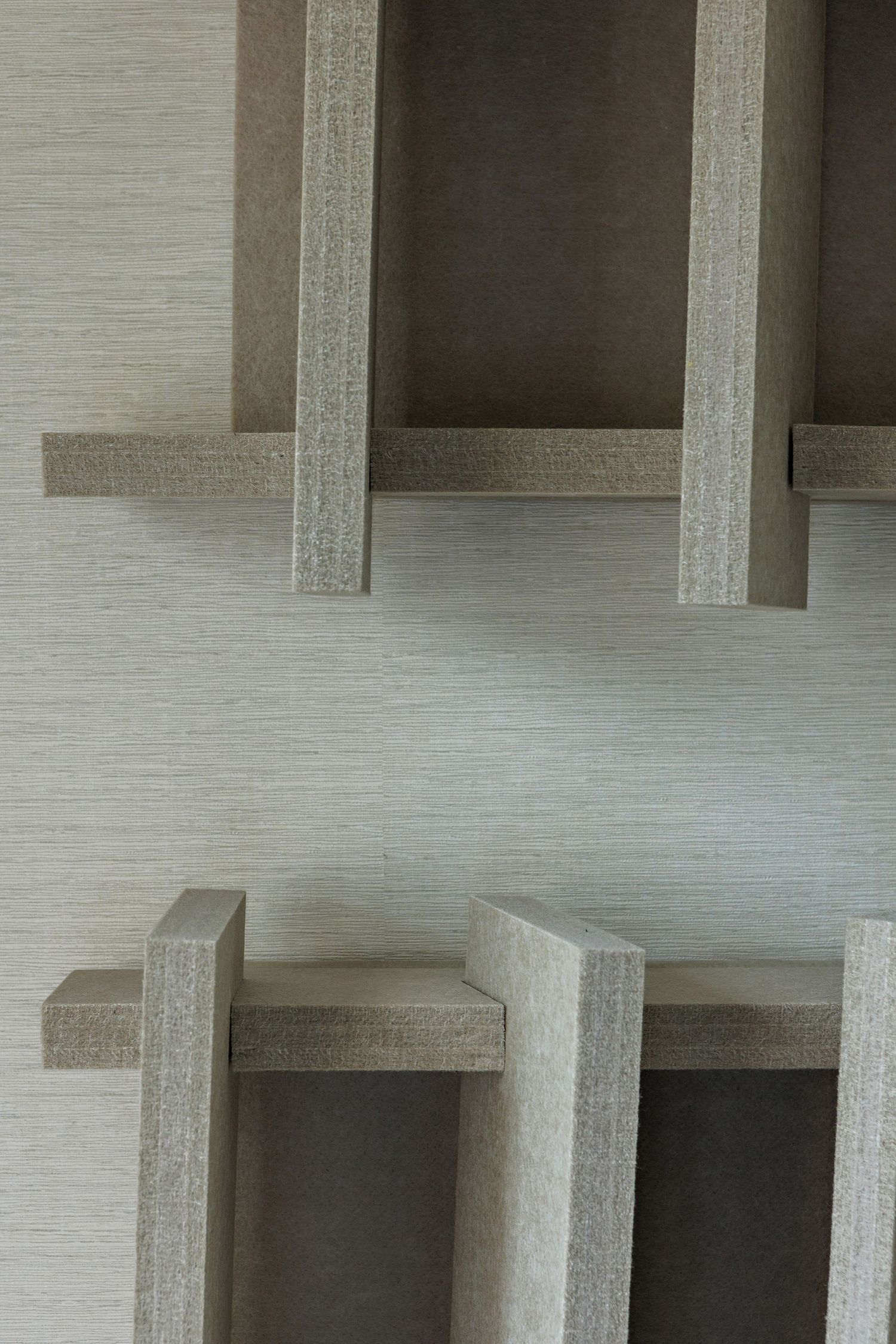 Abstract architectural detail showing repeating concrete columns and beams creating a geometric grid pattern.