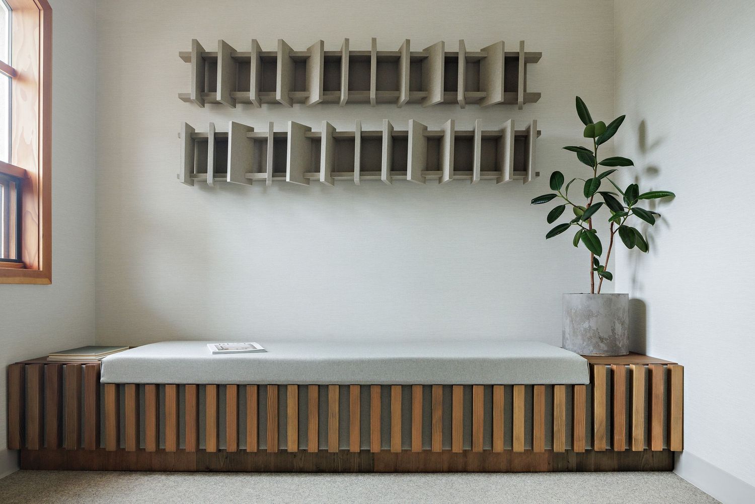 Modern wooden slat bench with metal frame sits beneath a white wall-mounted air conditioning unit.