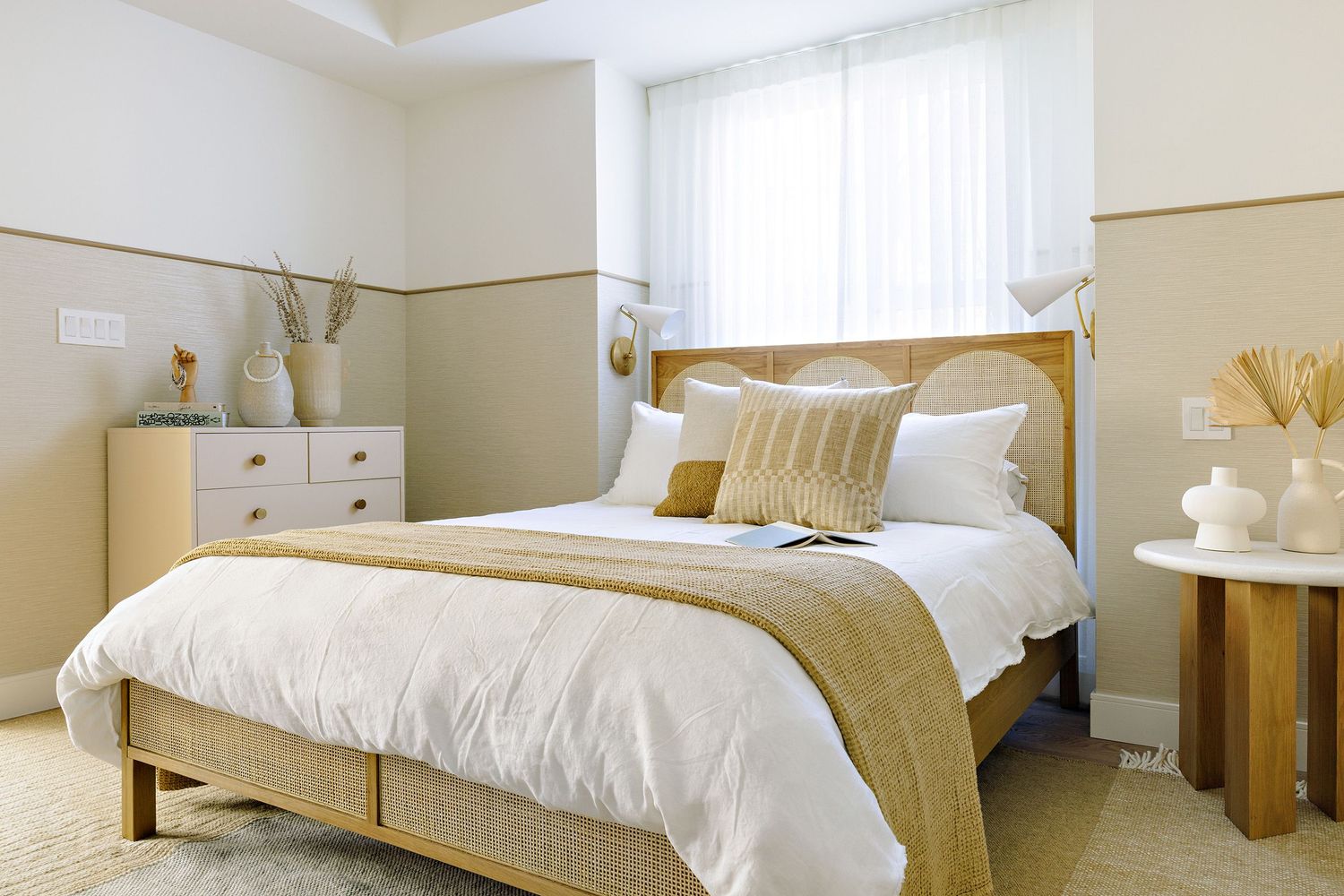 Serene bedroom design with white and gold color scheme, featuring plush bedding and wooden furniture.
