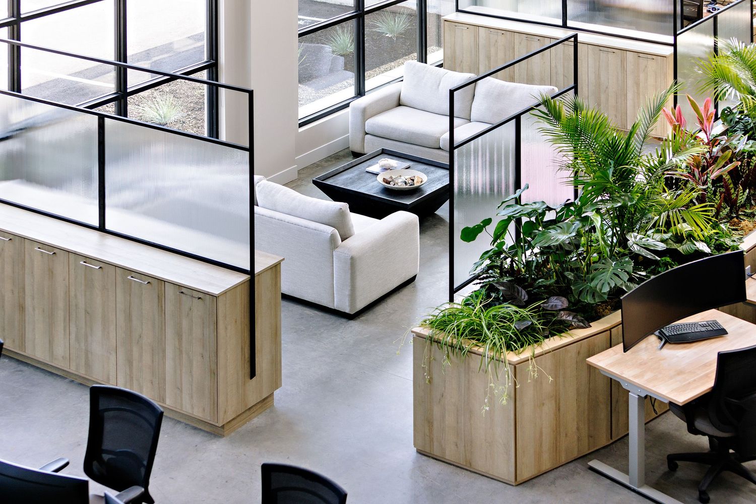 Modern office interior with wood planters, white furniture, and glass partitions in an open workspace design.
