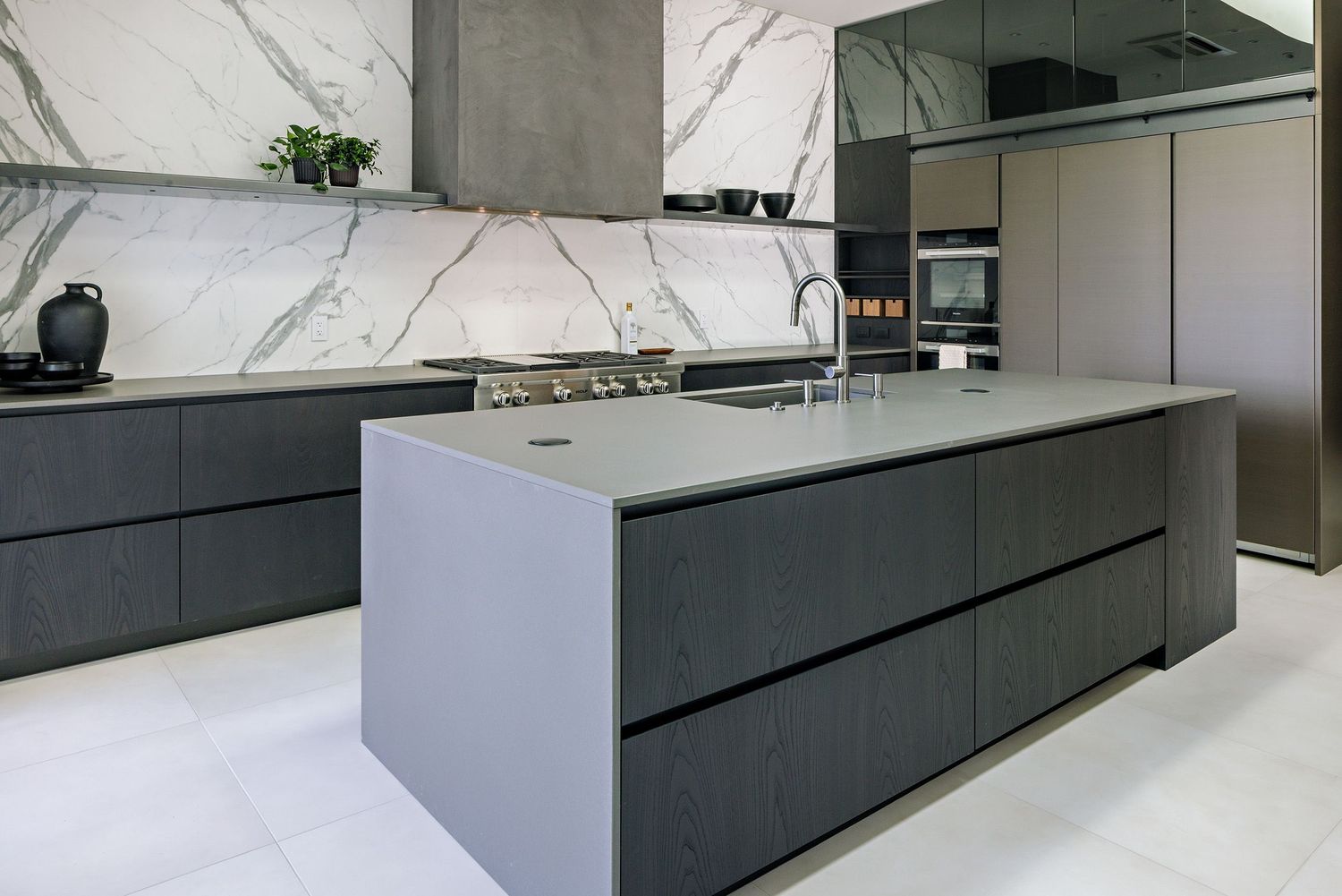 Modern black and white kitchen featuring sleek cabinetry, marble backsplash, and minimalist design elements.