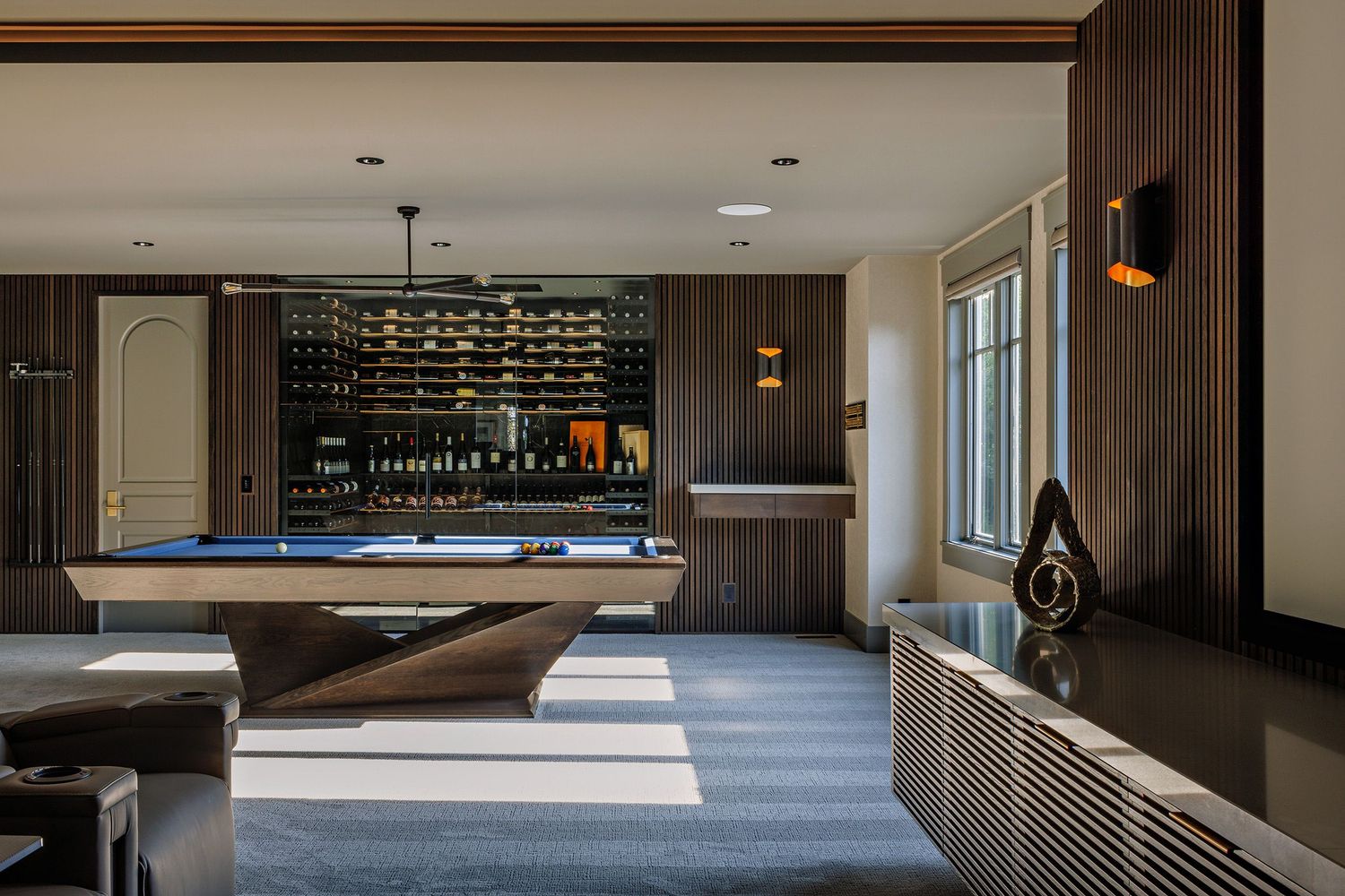 Modern luxury hotel hallway with wood paneling, recessed lighting, and plush carpeting creates an elegant atmosphere.
