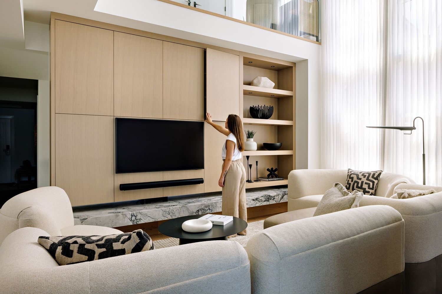 Contemporary living room with built-in entertainment center and cream-colored sectional sofa.