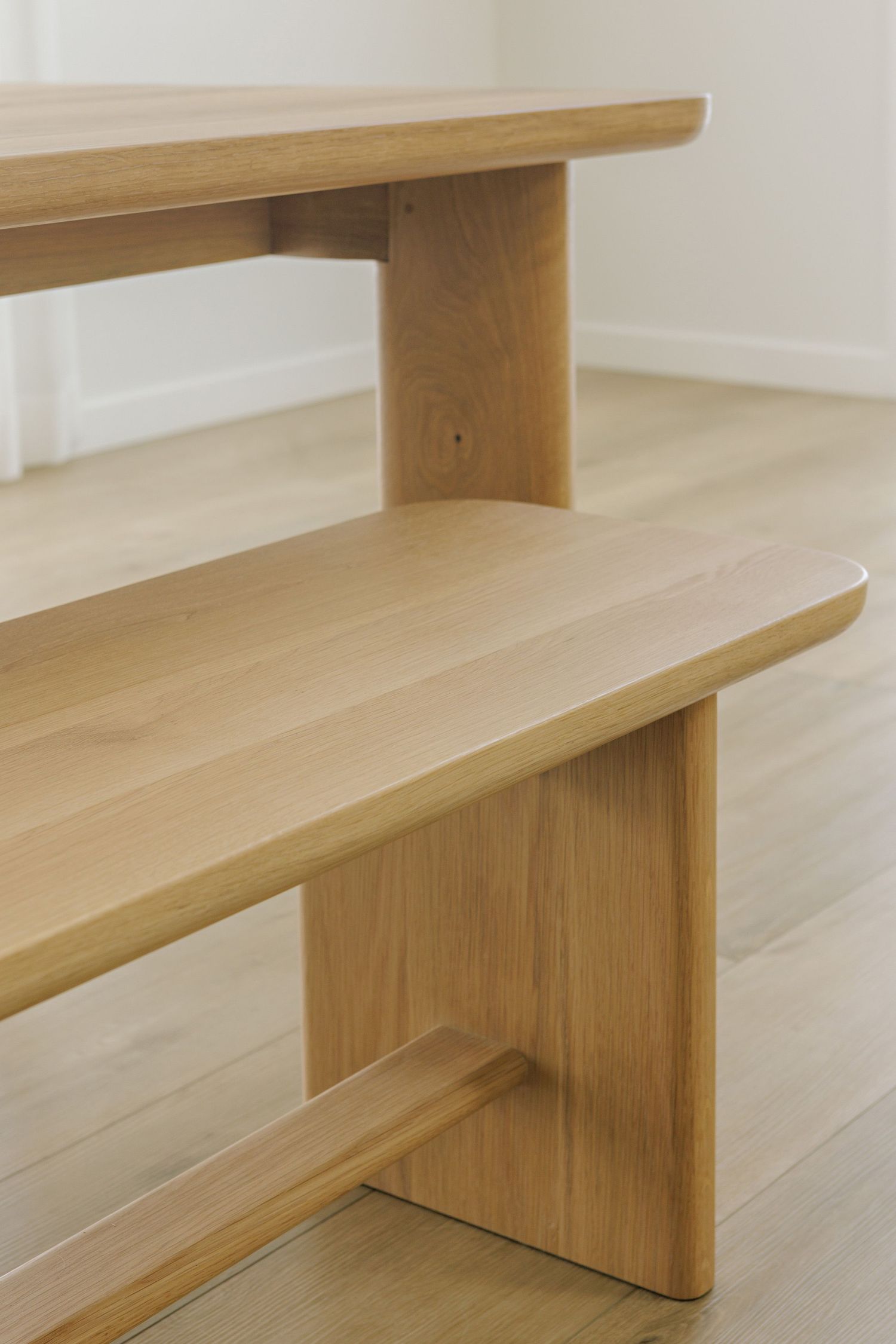 Modern wooden bench with clean lines and minimalist design showcases natural wood grain against light flooring.