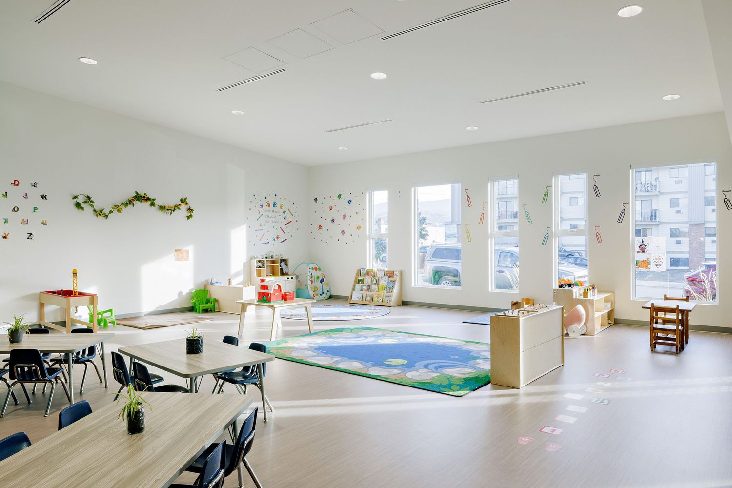 Modern white office space with panoramic windows, sleek furniture and minimalist decor in an open floor plan layout.