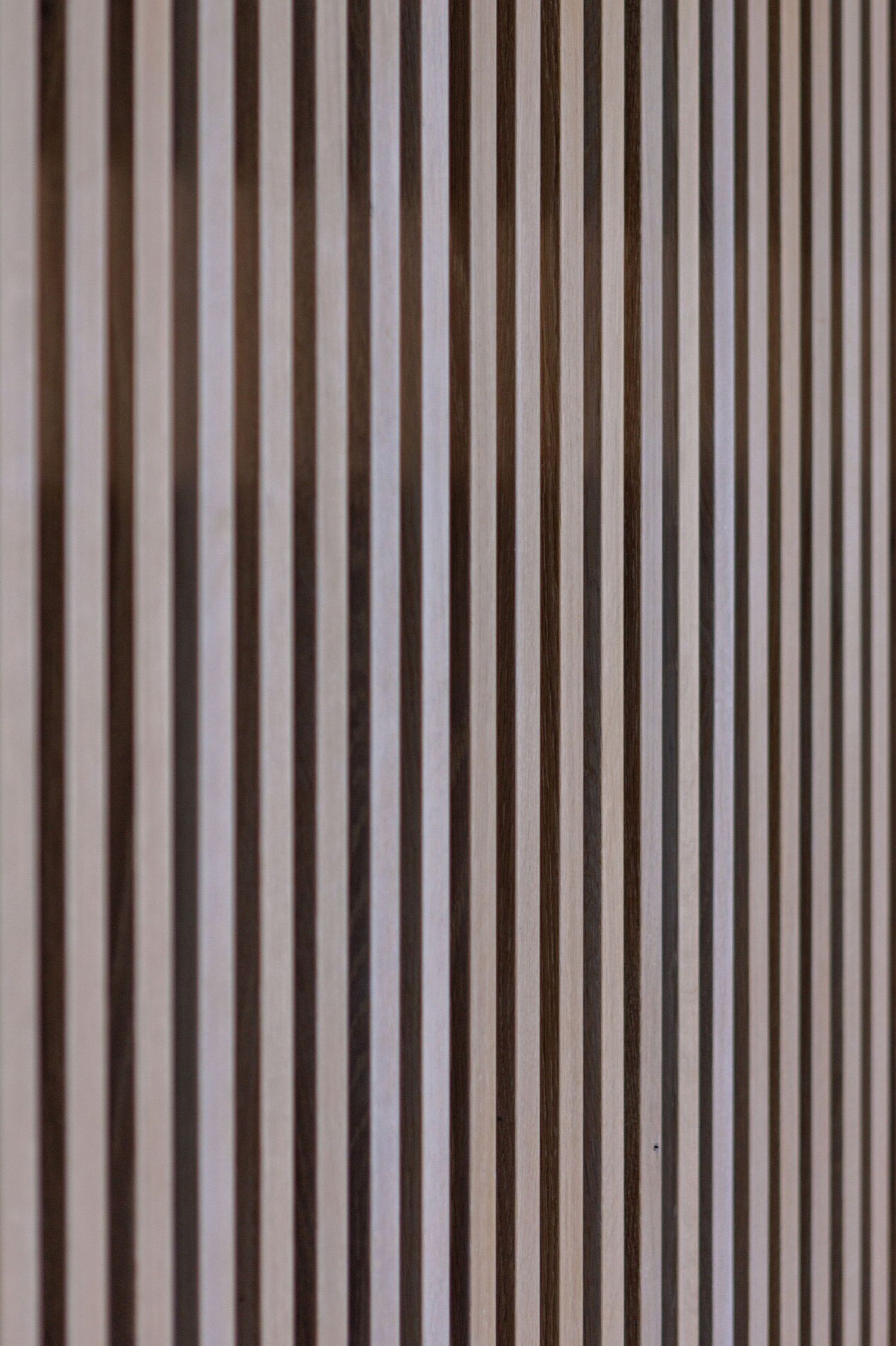 Close-up view of parallel vertical wooden slats creating a modern architectural pattern in brown tones.