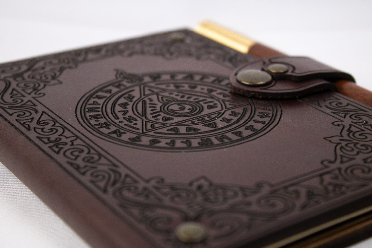 Vintage brown leather journal with Celtic knot design and brass closure photographed from multiple angles.