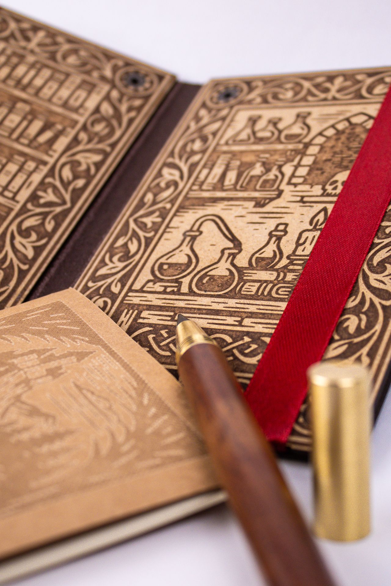 Close-up view of wooden board with intricate laser-engraved patterns and a red ribbon bookmark detail.
