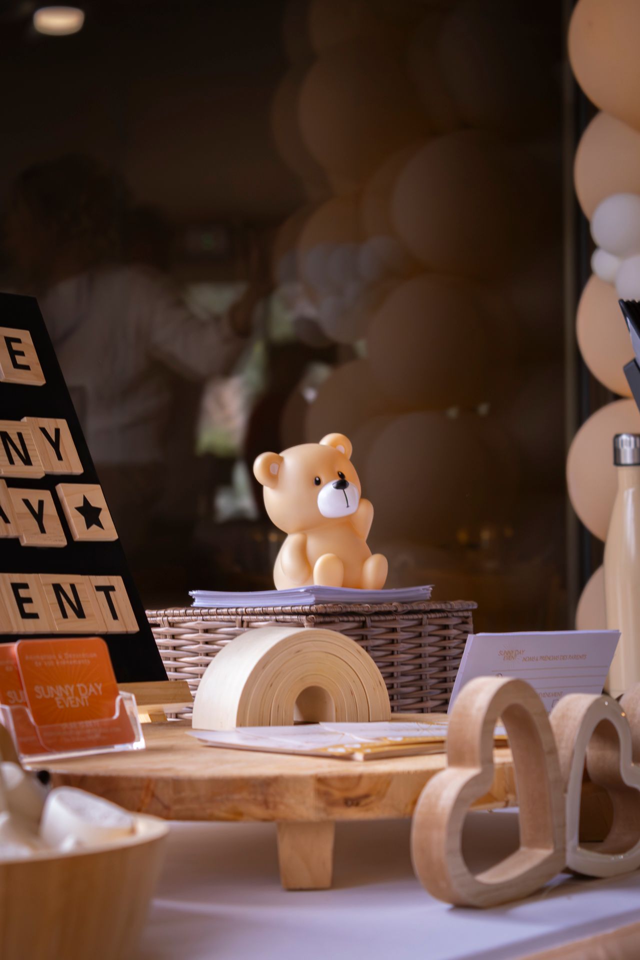 Wooden alphabet blocks and toys arranged on a white surface with woven baskets in a warm, dim lighting.