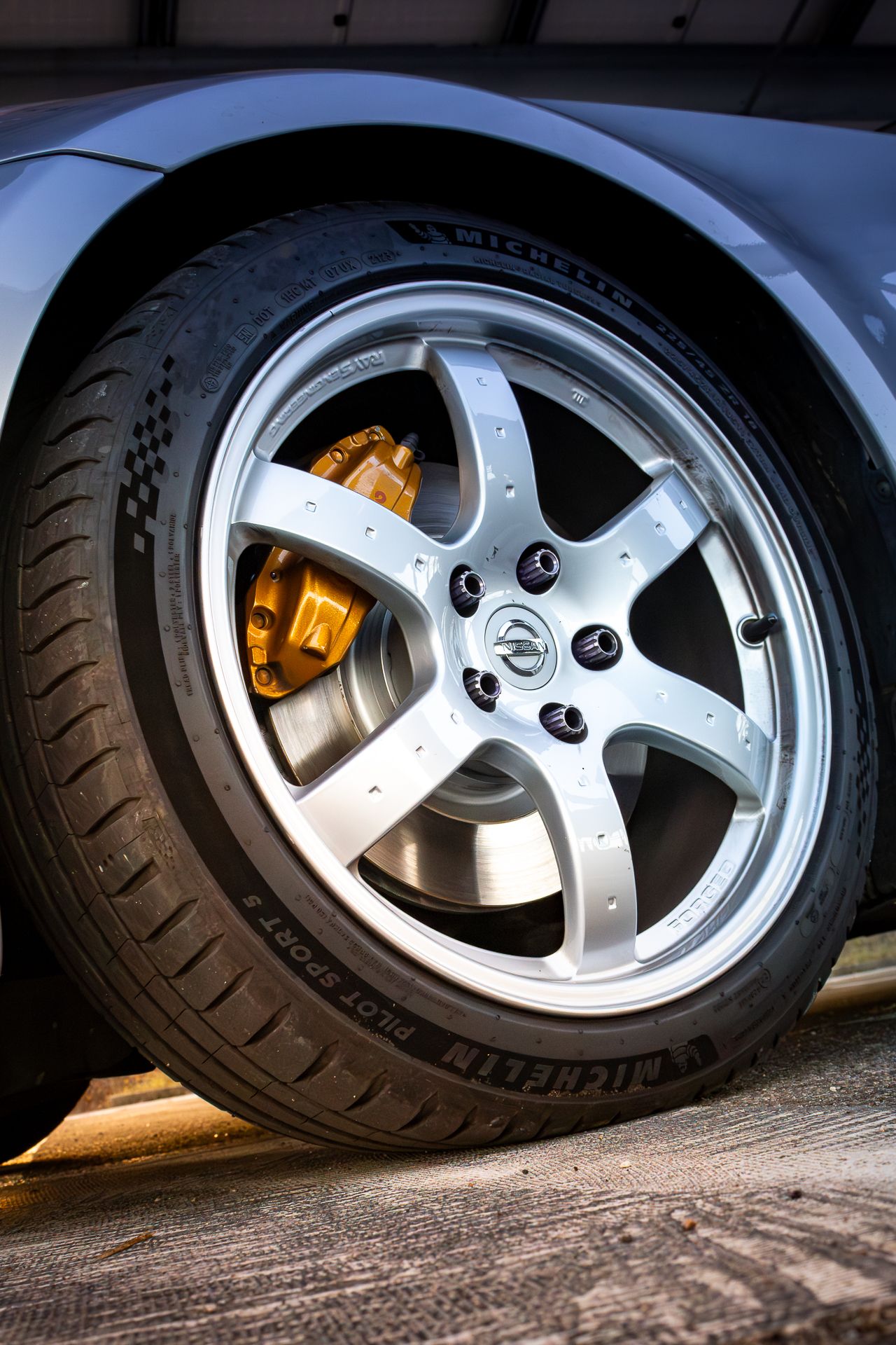 Close-up shots of silver alloy wheels with yellow brake calipers on a sports car from multiple angles.