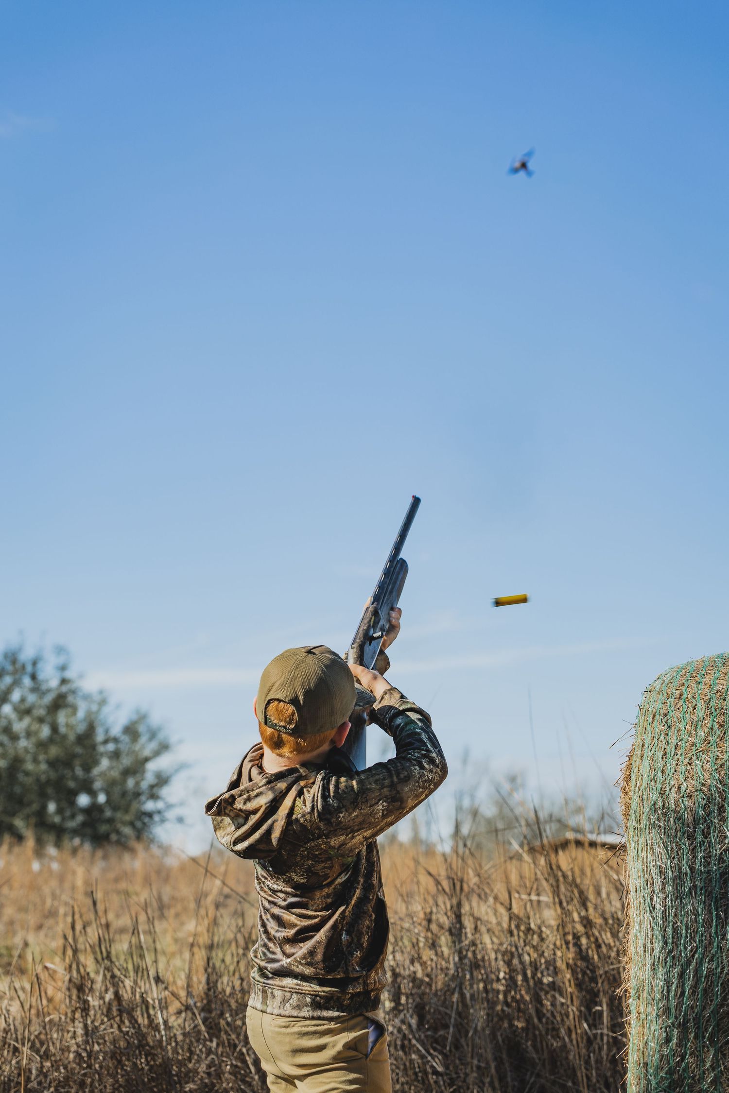 Hunter taking aim at birds flying against blue sky in sequential shots.