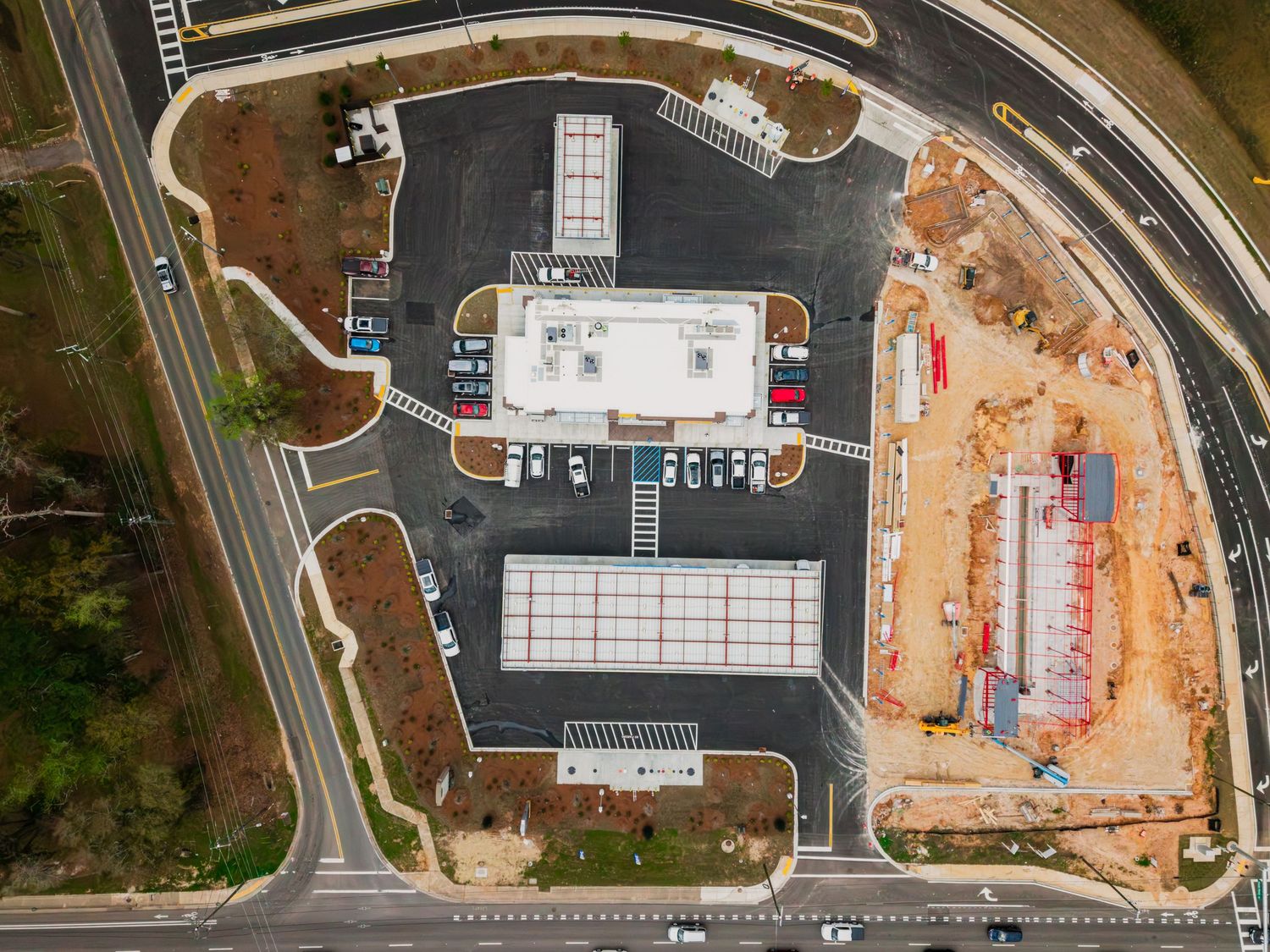 Aerial view of a construction site with curved roads and buildings under development in an urban area.